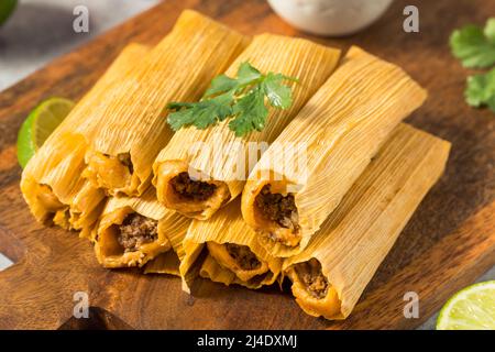 Homemade Beef Cornmeal Tamales with Salsa and Crema Stock Photo