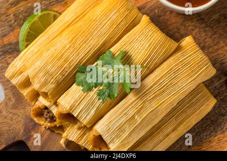 Homemade Beef Cornmeal Tamales with Salsa and Crema Stock Photo