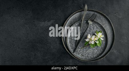 Place table setting with blossoming apple tree branches and flowers Stock Photo