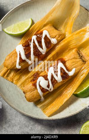 Homemade Beef Cornmeal Tamales with Salsa and Crema Stock Photo