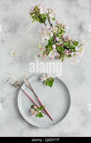 Place table setting with blossoming apple tree branches and flowers Stock Photo