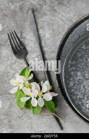 Place table setting with blossoming apple tree branches and flowers Stock Photo