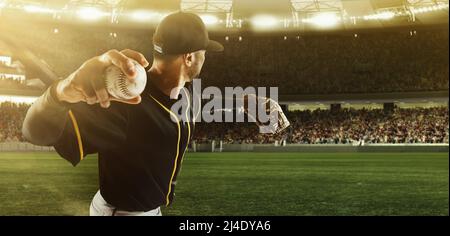 Professional baseball player taking a shot during match in crowed sport stadium at evening time. Sport, win, winner, competition concepts. Stock Photo