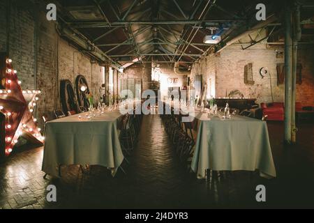 Dalston, London, UK - February 18, 2016: 2 log banqueting tables are ready to receive guests. Stock Photo
