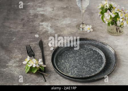 Place table setting with blossoming apple tree branches and flowers Stock Photo
