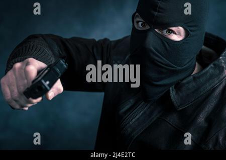thief with balaclava in threatening pose Stock Photo