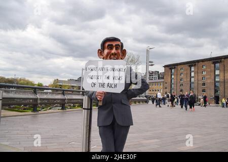 London, UK, 14th April 2022. A protester wearing a Rishi Sunak mask in Granary Square. Extinction Rebellion activists held an 'outreach day' in King's Cross, engaging with the public and demanding that the government acts on the ecological and climate crisis. Credit: Vuk Valcic/Alamy Live News Stock Photo