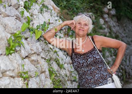 Senior Woman Relaxing by the sea Stock Photo