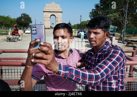 Tourist taking selfies with their smartphones in front of India Gate. War memorial located astride the Rajpath, on the eastern edge of the 'ceremonial axis' of New Delhi, formerly called Kingsway Stock Photo
