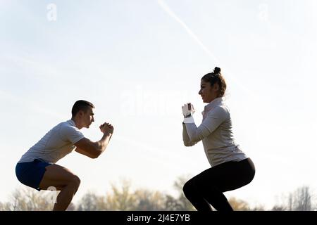 Two amazing and attractive fit friends are doing squad exercise and smiling, close up Stock Photo