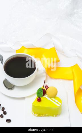Cup with coffee and lemon cake in the form of a heart Stock Photo