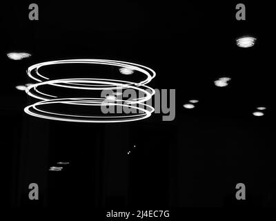 Ruti, Switzerland - April 8, 2021: Monochrome photo of a large circular halogen room lamp and its reflection in a window Stock Photo