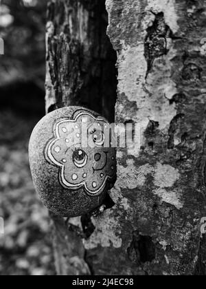 Zurich, Switzerland - April 8, 2022: Monochrome image of a figure on a stone in a tree crevice Stock Photo