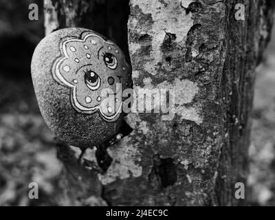 Zurich, Switzerland - April 8, 2022: Monochrome image of a figure on a stone in a tree crevice Stock Photo