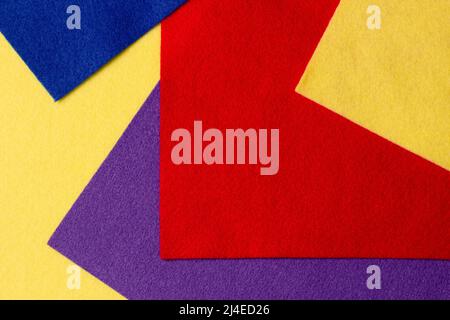 Abstract colorful geometric felt texture background. Bright yellow, blue, red, purple colors felt textile for craft. Top view, flat lay Stock Photo