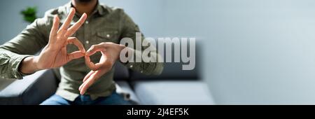Man Using Sign Language To Communicate At Home Stock Photo