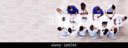 Positive Young Specialists With Stethoscope Having Discussion Of Research Work In Conference Room Stock Photo