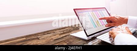 Businessman Working With Spreadsheet On Laptop In Office Stock Photo