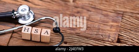 HSA Health Savings Account Wooden Blocks Near Stethoscope On Wooden Table Stock Photo