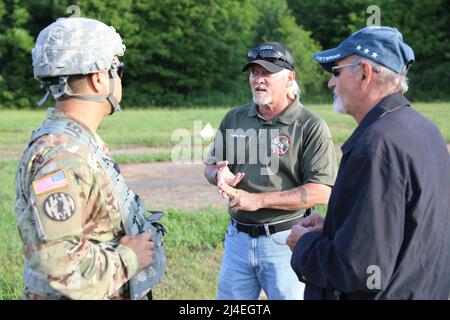 Counter Mortar Radar  - New York Army National Guard Chief Warrant Officer 2 Carlos Perez, the Target Acquisition Platoon Leader for the Radar Section with the 27th Infantry Brigade Combat Team, receives setup instructions from Randy Scott (center) and Jacques Hamellin, instructors with PM Radars, while fielding the new AN/TPQ-50 Lightweight Counter Mortar Radar (LCMR) on July 31, 2019, at Fort Drum, New York. Scott and Hamellin travel year round to multiple Military installations training Soldiers on radar systems. ( U.S. Army National Guard photo by Sgt. Andrew Winchell ) Stock Photo