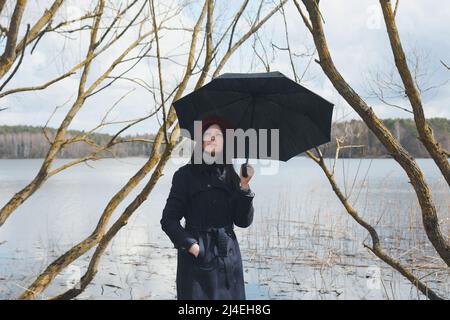 Portrait of a young nice woman with black umbrella outdoors Stock Photo