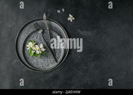 Place table setting with blossoming apple tree branches and flowers Stock Photo