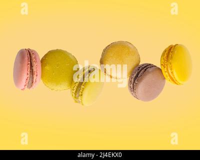 Appetizing French pastries - macaroons on a pale yellow background. Minimalism. There are no people in the photo. There is free space to insert. Holid Stock Photo