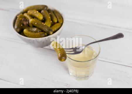 Pickled juice, pickle and marinated cucumber in bowl Stock Photo