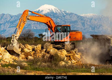 Stone filled crusher with stone crusher and bucket Stock Photo