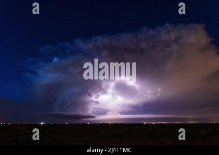 Lightning illuminates a supercell thunderstorm cloud in the night sky near Littlefield, Texas Stock Photo