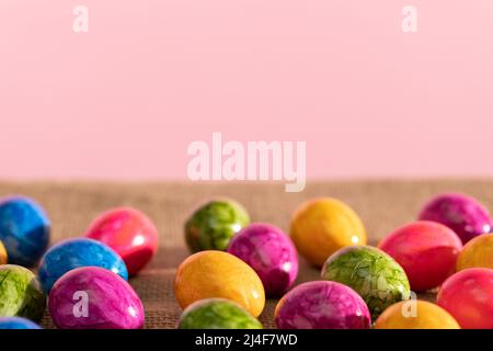 Scattered colored chicken eggs on linen fabric. Easter. Stock Photo