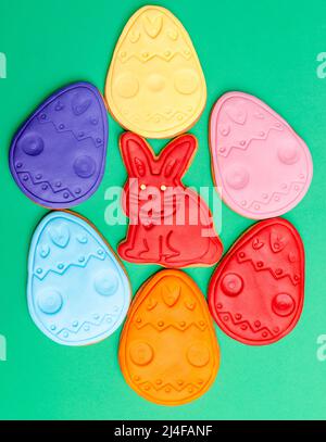 Colored gingerbread rabbits and eggs on green background. A holiday of religion. Stock Photo