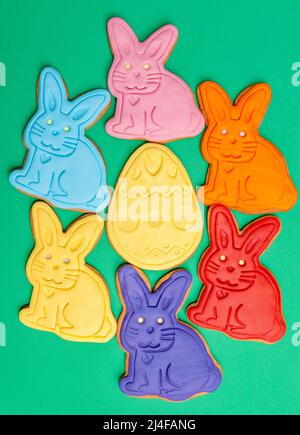 Colored gingerbread rabbits and eggs on green background. A holiday of religion. Stock Photo