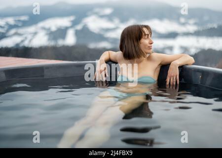 Woman bathing in hot tub at mountains Stock Photo