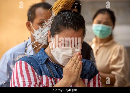 Bangkok, Bangkok, Thailand. 15th Apr, 2022. A member of the public has water splashed on their head by a monk in order to receive a blessing at Bangkok's Wat Pho temple. Thailand's traditional new year celebration based on the lunar calendar, Songkran, also known as the water festival, usually takes place every year during April or May. Temples throughout the country put on special festivities and traditional activities for the multi day event, which falls on April 13-15 in 2022. (Credit Image: © Adryel Talamantes/ZUMA Press Wire) Stock Photo