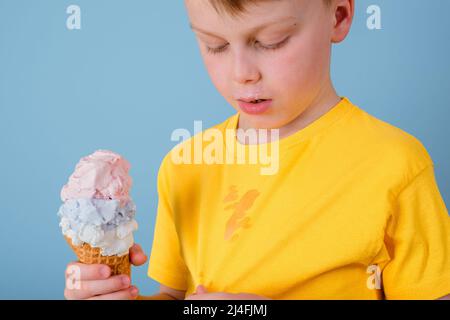 The child showing a dirty stain from ice cream on his clothes. He holding an ice cream cone in his hand. Stock Photo