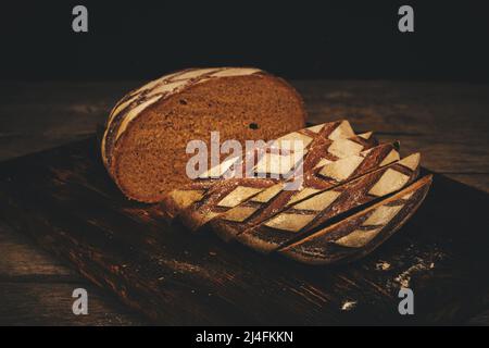 Sliced black rye bread on a cutting wooden board Stock Photo