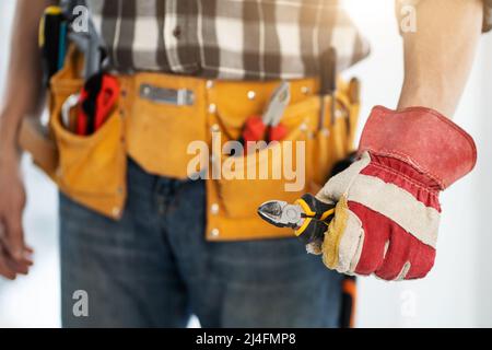 Repairman holding side cutters in hand Stock Photo