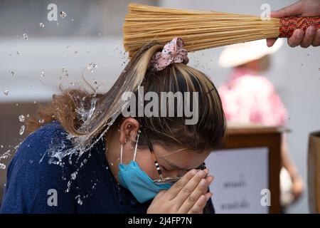 Bangkok, Thailand. 15th Apr, 2022. A monk splashes water on a member of the public in order to give a blessing at Bangkok's Wat Pho temple. Songkran, Thailand's traditional new year celebration which follows the lunar calendar, is normally marked by large street gatherings which turn into massive water fights. Due to the pandemic the last three year's activities have been more subdued. Credit: SOPA Images Limited/Alamy Live News Stock Photo