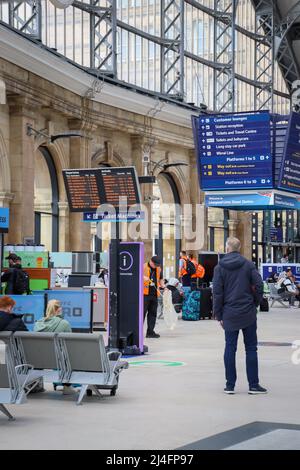 Man / Passenger observing the arrivals / departure boards at Lime Steet Train Station, Liverpool Stock Photo