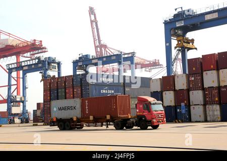 LIANYUNGANG, CHINA - APRIL 15, 2022 - Transport vehicles transfer containers to cargo ships at the Lianyungang Container Terminal in Lianyungang city, Stock Photo