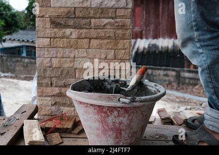 Man working stone tile on new house pole interior building Stock Photo