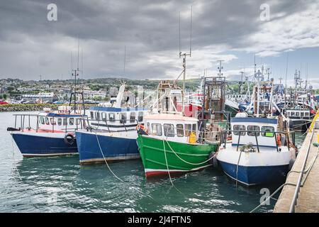 Four small fishing boats moored in Howth harbour. Phishing and shellfish fishing equipment on fishing boats, Dublin, Ireland Stock Photo