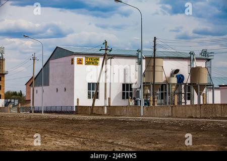 Kyzylorda Province, Kazakhstan - May 01, 2019. Rice processing plant. Main building and loading hoppers. Blue sky, clouds. Stock Photo