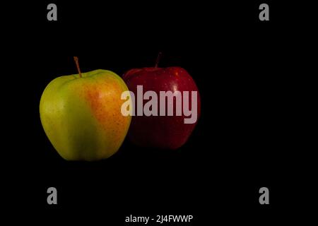 one yellow and one red apple on a black background, ideal for wallpapers Stock Photo
