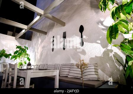 Ios, Greece - June 13, 2021 : View of a beautiful decorated table on an outdoor terrace at night in Ios Greece Stock Photo