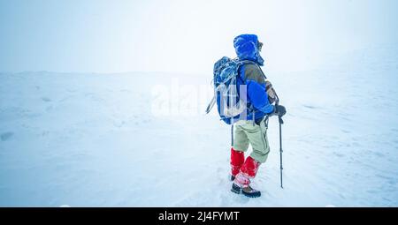 Hiker standing on snowy winter mountain Stock Photo