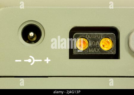 External power output sockets on the camera battery. Negative positive symbols and maximum output power in amps. Stock Photo