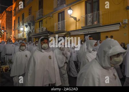 Sorrento, Italy. 14th Apr, 2022. Hooded Penitents of the Arciconfraternita di Santa Monica carry crosses and torches as they take part in Good Friday procession long the streets of Sorrento Southern Italy. Christian believers around the world mark the Holy Week of Easter in celebration of the crucifixion and resurrection of Jesus Christ. Sorrento on April 15, 2022 in Naples, Italy. Credit: Franco Romano/Alamy Live News Stock Photo