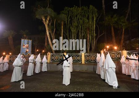 Sorrento, Italy. 14th Apr, 2022. Hooded Penitents of the Arciconfraternita di Santa Monica carry crosses and torches as they take part in Good Friday procession long the streets of Sorrento Southern Italy. Christian believers around the world mark the Holy Week of Easter in celebration of the crucifixion and resurrection of Jesus Christ. Sorrento on April 15, 2022 in Naples, Italy. Credit: Franco Romano/Alamy Live News Stock Photo